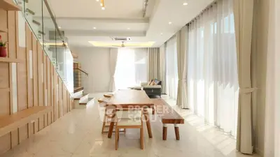 Spacious modern living room with large windows and elegant wooden furniture