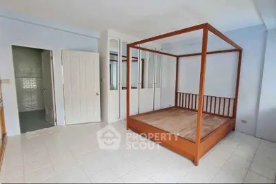 Spacious bedroom with elegant wooden bed frame and built-in wardrobe