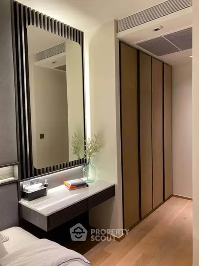 Modern bedroom with sleek design, featuring a built-in wardrobe and elegant vanity area.
