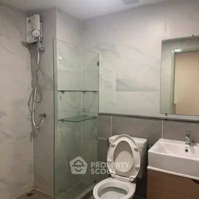 Modern bathroom with glass shower and sleek fixtures in a contemporary apartment.