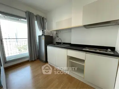 Modern kitchen with sleek cabinetry and large window offering city views, perfect for urban living.