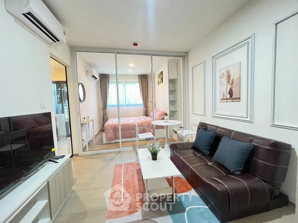 Modern living room with stylish decor and cozy bedroom view in open layout apartment.