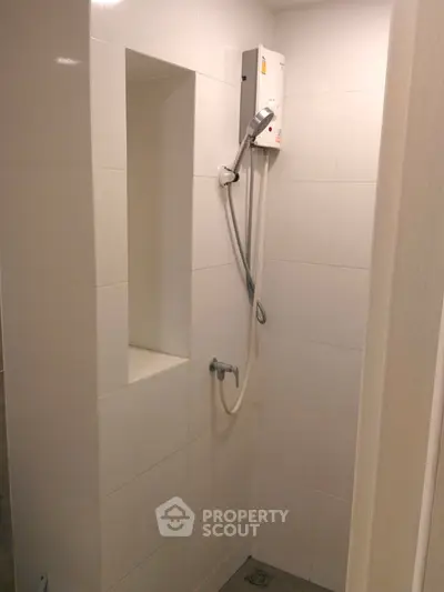 Compact bathroom with white tiles and modern shower unit