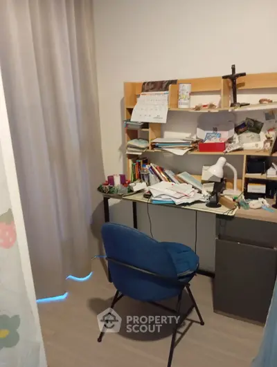 Cozy study room with desk, chair, and shelves filled with books and decor.