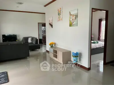 Spacious living room with modern decor and adjacent bedroom in a stylish home.