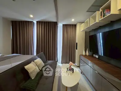 Modern living room with sleek furniture and large TV, perfect for relaxation and entertainment.