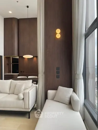 Luxurious modern living room with elegant furniture and floor-to-ceiling windows offering stunning city views.