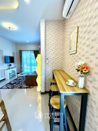 Modern living room with stylish decor and breakfast bar, featuring cozy seating and elegant lighting.