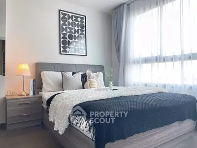 Modern bedroom with stylish decor and natural light, featuring a cozy bed and elegant furnishings.