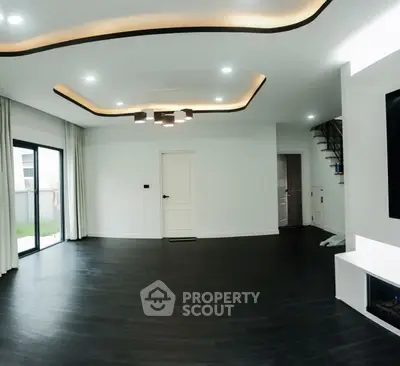 Spacious modern living room with elegant lighting and dark wood flooring