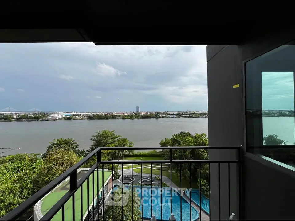 Stunning river view from a modern balcony overlooking a pool and lush greenery.