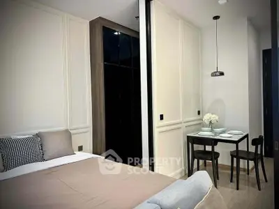 Modern bedroom with dining area, featuring sleek furniture and elegant decor.