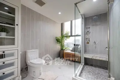 Spacious modern bathroom with glass shower and city view.