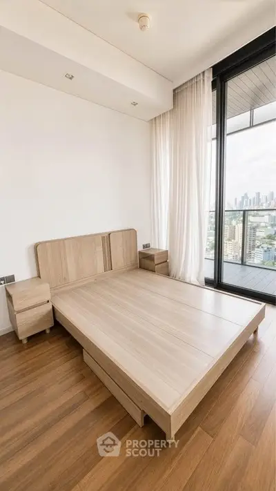Modern bedroom with wooden flooring and city view balcony