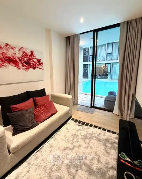 Modern living room with pool view, cozy seating, and stylish decor in a luxury apartment.