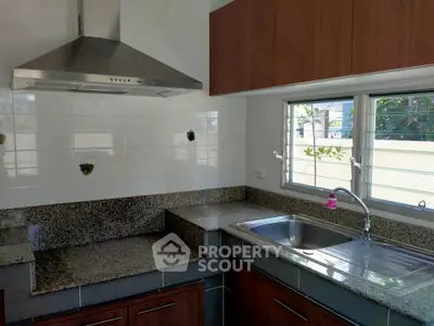 Modern kitchen with granite countertops and stainless steel range hood