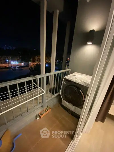 Cozy balcony with washing machine and night view, perfect for urban living.