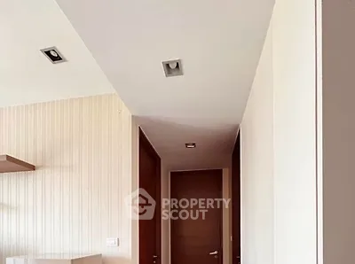Modern hallway with wooden doors and recessed lighting