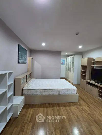 Spacious bedroom with modern furnishings and wooden flooring