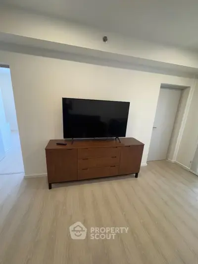 Modern living room with sleek wooden TV stand and flat-screen television