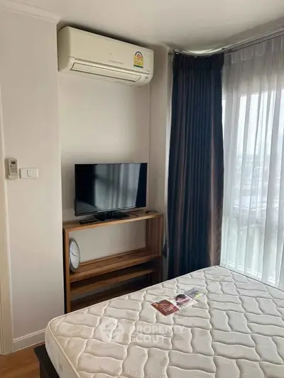 Cozy bedroom with air conditioning and natural light, featuring a TV and modern furnishings.