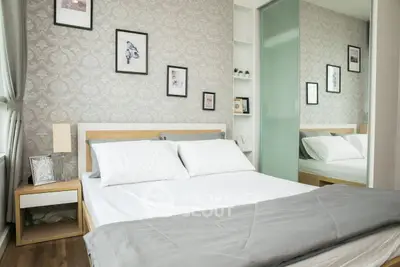 Modern bedroom with elegant decor, featuring a comfortable bed and stylish wallpaper.