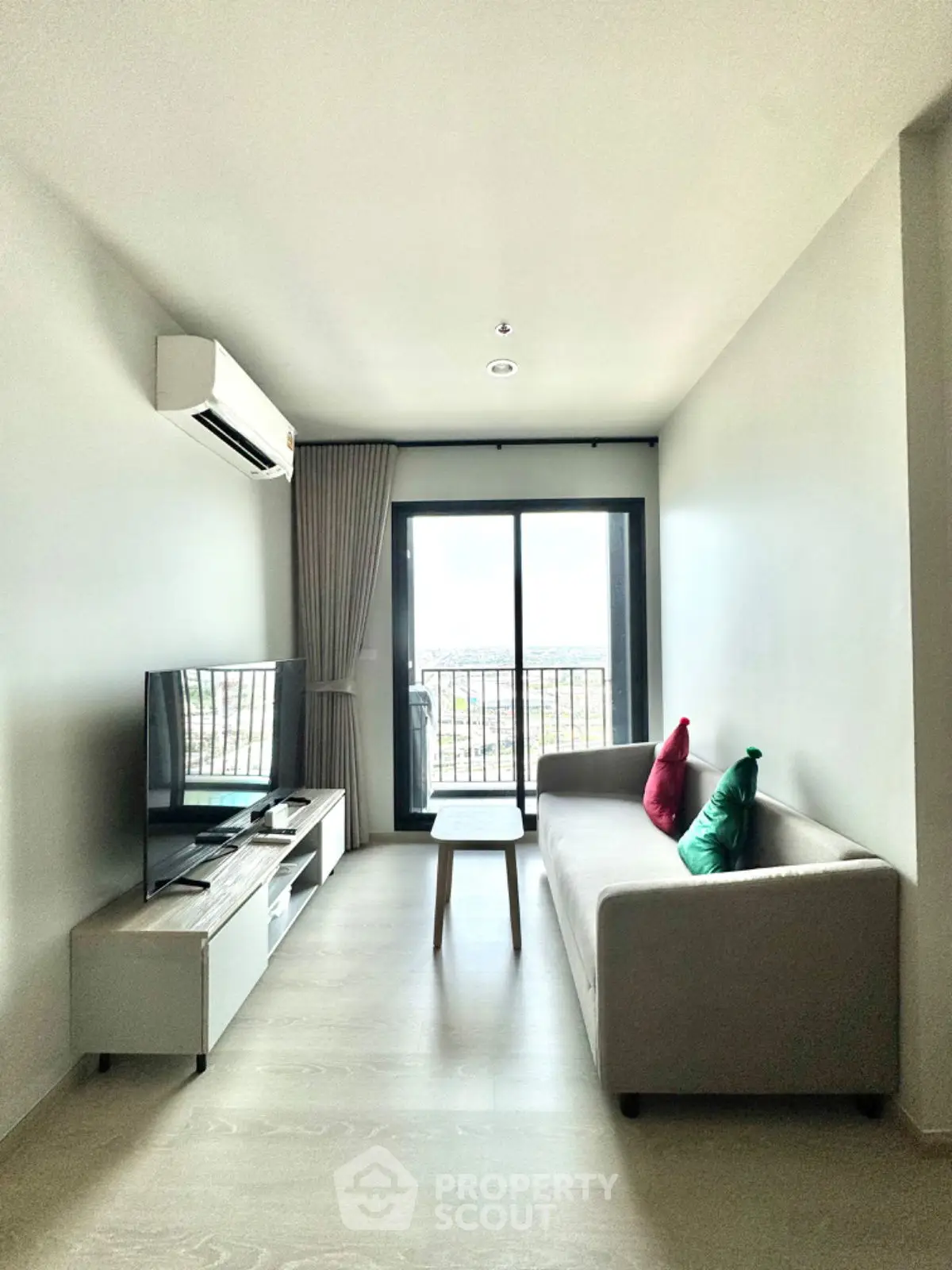 Modern living room with balcony view, sleek furniture, and natural light.