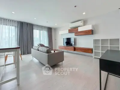 Spacious modern living room with sleek furniture and large windows for natural light.