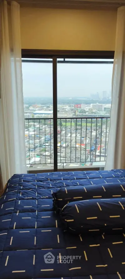 High-rise bedroom with stunning city view from large window, modern decor.