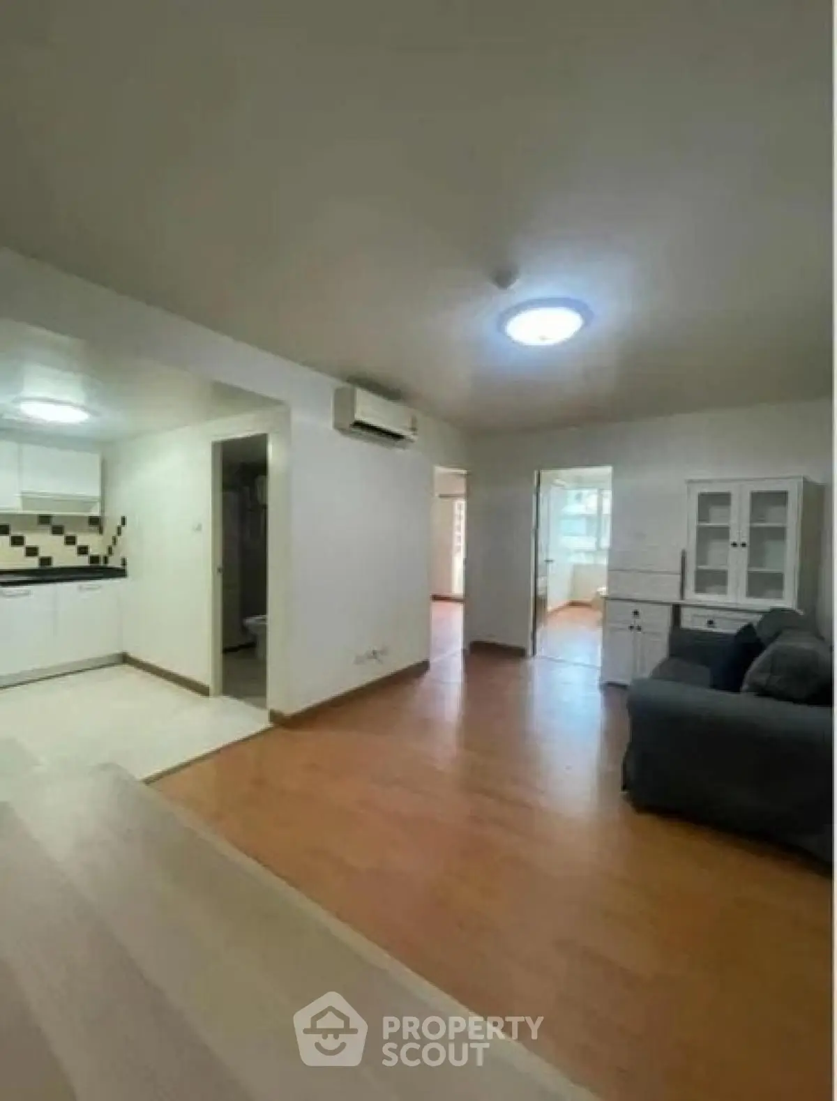 Spacious open-plan living room with modern kitchen in a bright apartment.