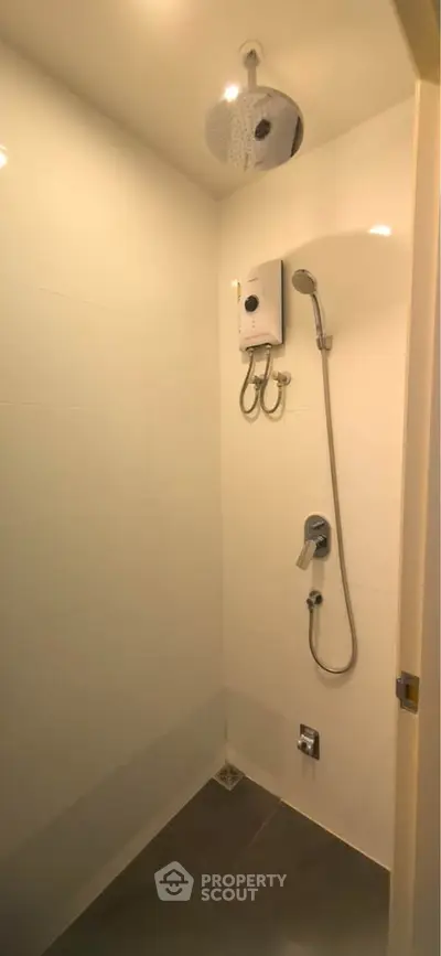 Modern bathroom shower area with sleek fixtures and overhead showerhead.