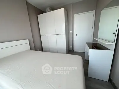 Modern minimalist bedroom with white furniture and sleek design.