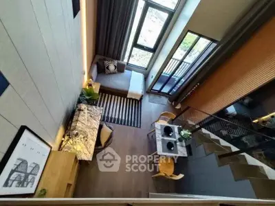 Stunning modern loft with high ceilings and large windows, featuring elegant dining area and stylish decor.