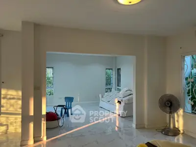 Spacious interior with natural light, white marble flooring, and cozy seating area.