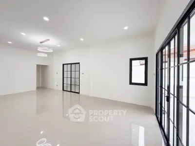 Spacious modern living room with sleek tile flooring and large windows for natural light.