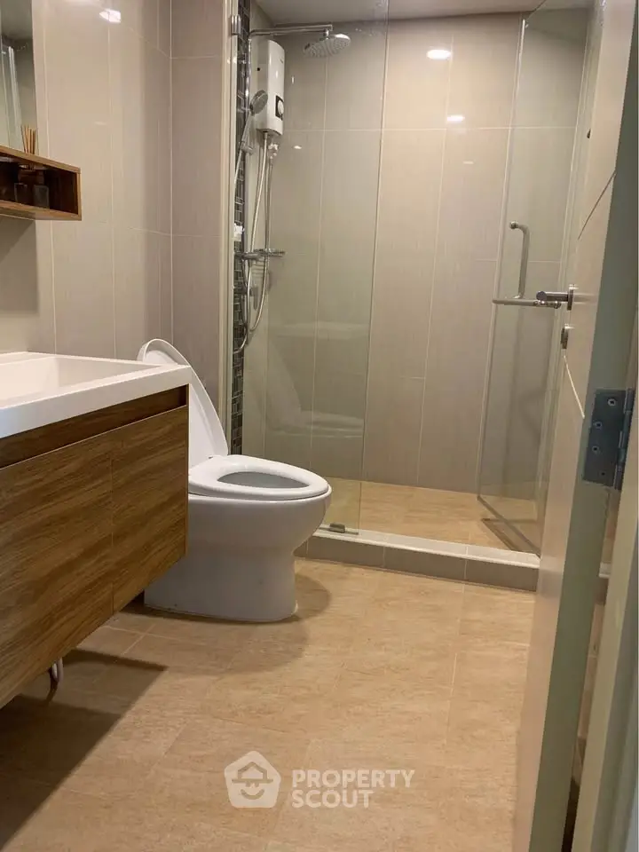 Modern bathroom with glass shower and sleek wooden vanity