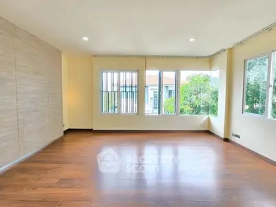 Spacious empty living room with large windows and wooden flooring