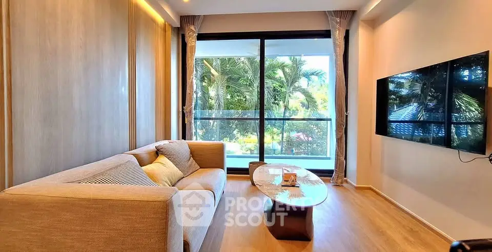 Modern living room with large window and stylish furniture, offering a serene garden view.
