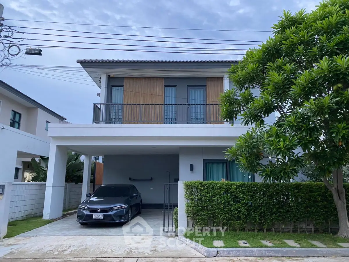 Modern two-story house with carport and lush greenery