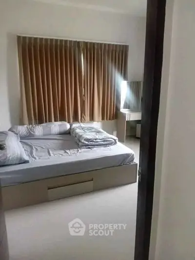 Cozy bedroom with large window and modern furnishings in a stylish apartment.