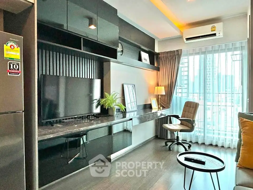 Modern living room with sleek black furniture and large window view in urban apartment.
