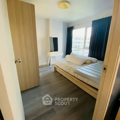 Cozy bedroom with modern furnishings and large window view