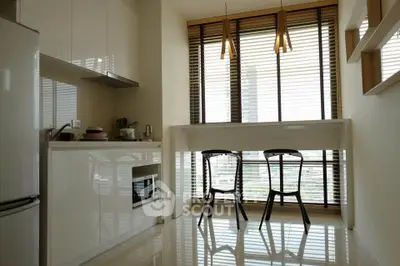 Modern kitchen with sleek design, featuring large windows and contemporary lighting.