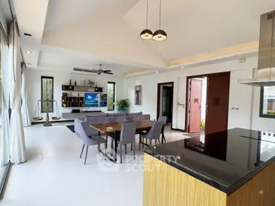 Spacious modern living room with open kitchen and elegant dining area, featuring high ceilings and stylish decor.