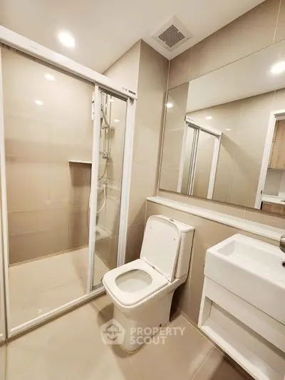 Modern bathroom with sleek shower and elegant fixtures in a contemporary apartment.