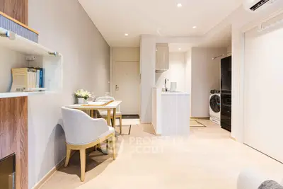 Modern open-plan living room with dining area and compact kitchen in a stylish apartment.