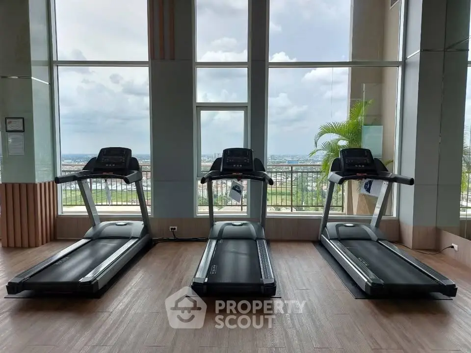 Modern gym with three treadmills and panoramic city view, perfect for fitness enthusiasts.