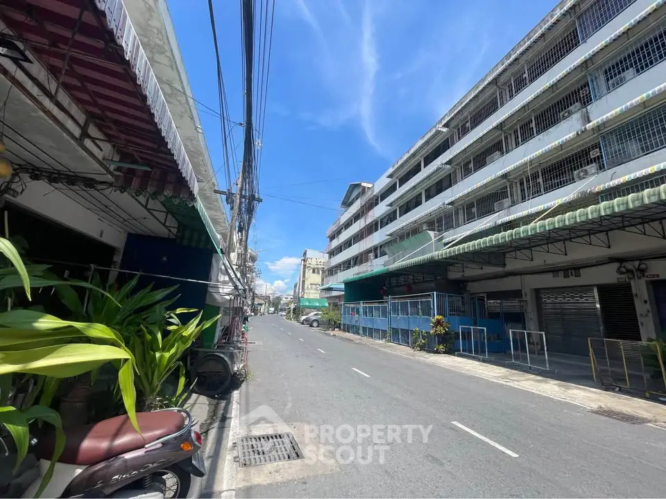 Street view of urban residential buildings under a clear blue sky.