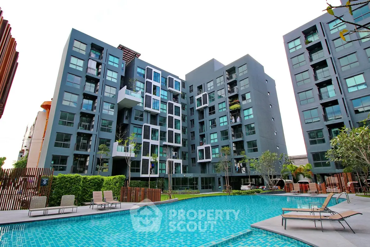 Modern apartment complex with pool and lush landscaping, offering a luxurious lifestyle in a prime location.
