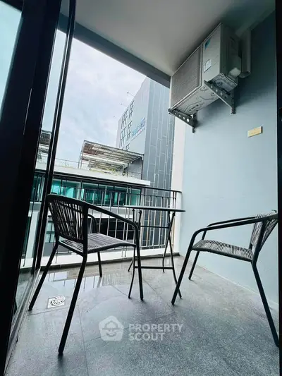 Modern balcony with sleek chairs and city view, perfect for relaxation and urban living.